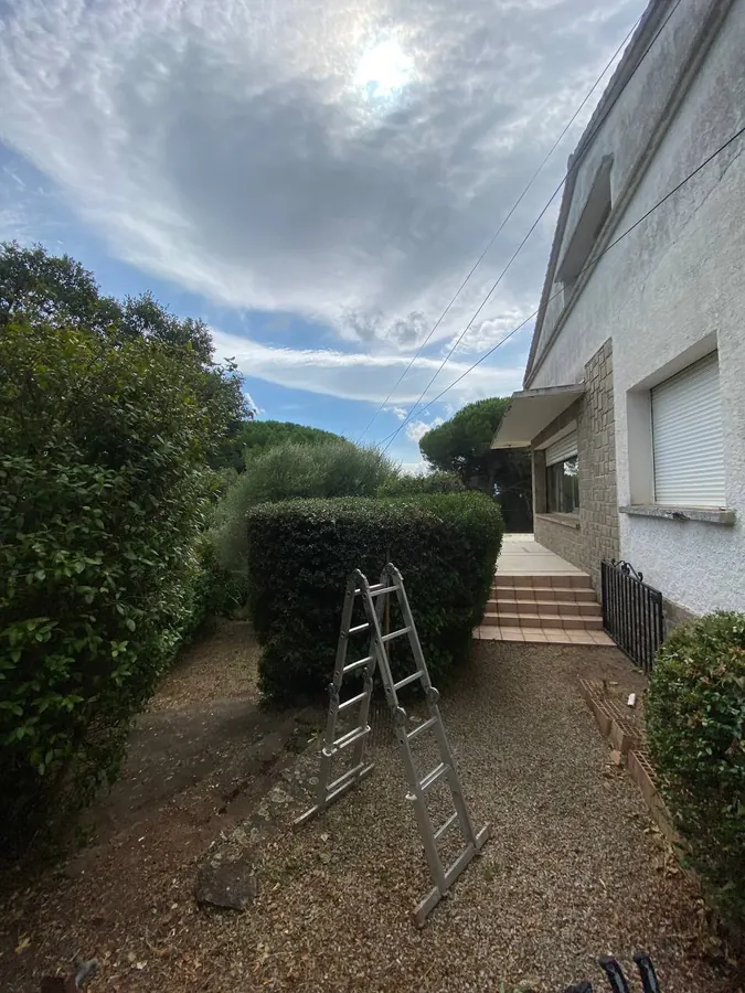 Échelle posée contre une haie reprise en forme arrondie devant une villa, chantier de taille en cours à Lorgues